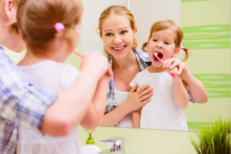 Happy Mother and daughter Brushing Teeth